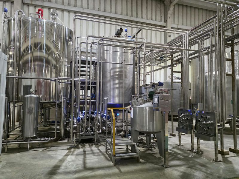 Planta de formulação com tanques de aço inox com agitador, escada de acesso e placas de fluxo